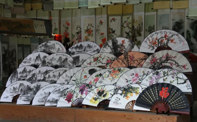 Hand-painted folding fans displayed in Fuli ancient town, Yangshuo, supplied by Guilin tourism’s official gltour account in 2024.