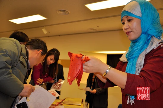 Hui paper-cut artist Tian Yanlan demonstrates a red paper cutting at the Ningxia heritage event in Tokyo on 25 December 2013.